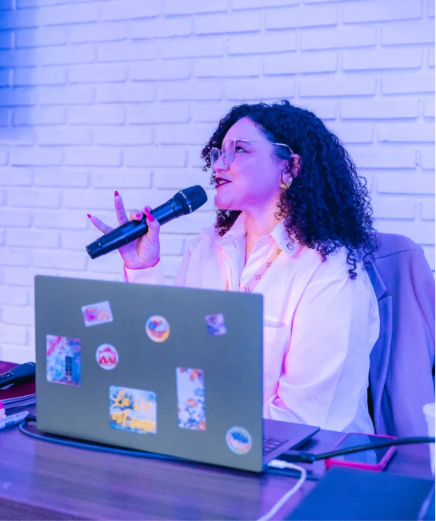 Jessica Ferreira com microfone e notebook, energia de mentoria, mostrando onde criar conteúdo a levou
